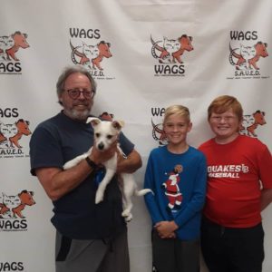 smiling kids and dad for new adopted white dog WAGS