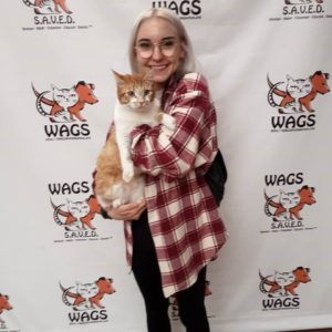 women in longwhite hair and red checkered adopted cat orange tabby